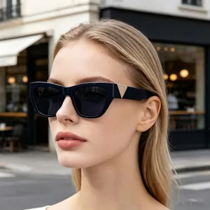 Detail shot of chic cat-eye sunglasses with gold triangle hinge on a fashion model