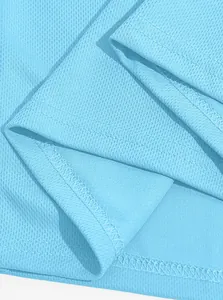 Close-up of light blue breathable mesh fabric and stitching on a men's Polo shirt.