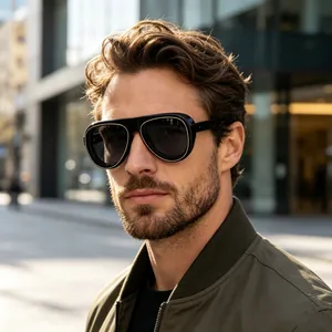Homme portant des lunettes aviateur noires avec détails dorés en milieu urbain.