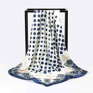 Detailed view of elegant blue polka dot and paisley prints on a luxurious satin silk scarf