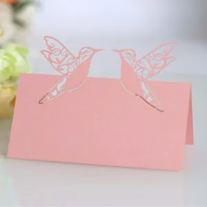 Elegant pink laser-cut hummingbird place cards for wedding tables and event seating decor.