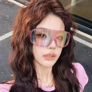Detailed view of oversized pink iridescent ski goggles worn by a female model outdoors