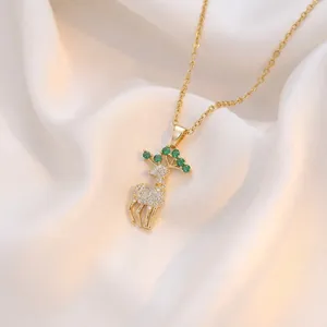 Détail du collier pendentif renne doré avec des pierres étincelantes vertes et blanches