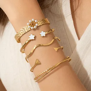 Élégant ensemble de bracelets dorés superposés avec fleur de perle et géométrie