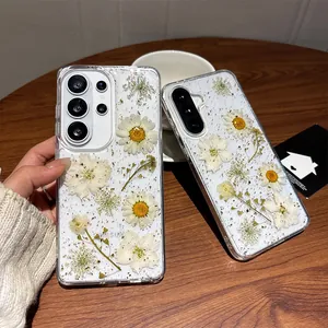 Detail showing transparent phone case with real pressed daisies and gold foil flakes