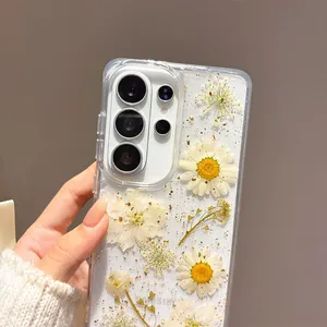 Detailed view of clear phone case with dried daisies and gold foil flakes