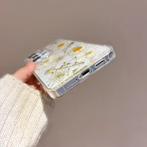 Detailed view of clear Samsung case featuring real dried daisies and gold foil flakes