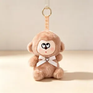 Adorable brown plush monkey keychain featuring a white lace bow and heart charm accessory
