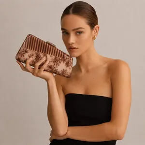 Elegant floral and striped acrylic evening clutch bag with metal clasp held by a model