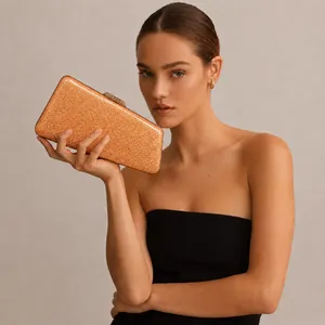 Close-up of elegant orange glitter acrylic evening clutch with gold metal clasp