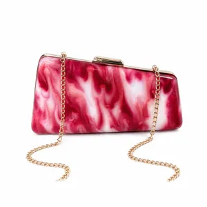 Stylish red marbled acrylic evening clutch featuring a gold-tone chain strap and clasp