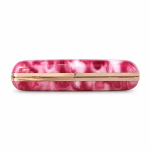 Detail shot of pink marble acrylic evening clutch with gold-tone metal frame.