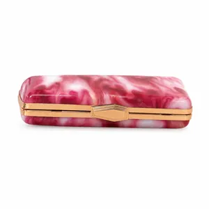 Detail view of a pink marbled acrylic evening clutch bag with gold-tone hardware clasp.