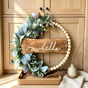 Rustic fall wreath with wooden beads, artificial leaves and a white hello sign plaque.