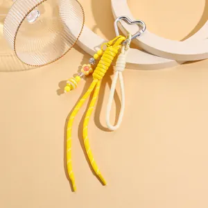 Detailansicht eines niedlichen gelben Seil-Taschenanhängers mit herzförmigem Metallclip.