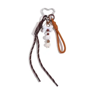 Detailansicht eines ins-Style Perlen-Taschenanhängers mit Herzkarabiner und Quasten.