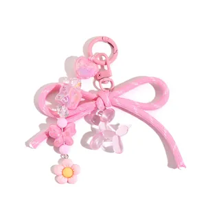 Detail eines rosa Schleifen-Schlüsselanhängers mit Herzperlen und Ballonhund-Charm
