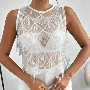 Détail d'un haut sans manches en résille blanche avec des franges à paillettes