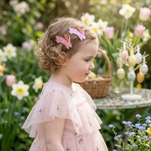 Barrettes à cheveux lapin de Pâques à paillettes roses portées par une fille en jardin