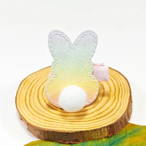 Vue rapprochée d'une pince à cheveux lapin à paillettes avec petit pompon blanc
