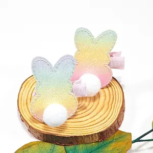Détail de pinces à cheveux lapin de Pâques pailletées arc-en-ciel avec doux pompons