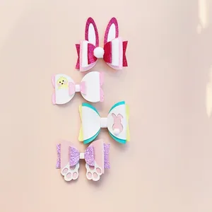 Détail de quatre pinces à cheveux pailletées de Pâques avec motifs lapins et poussins.