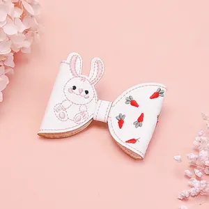 Vue détaillée d'un joli nœud à cheveux en similicuir blanc avec broderie lapin