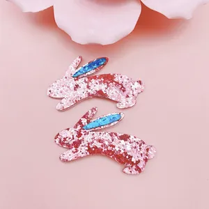 Détail de pinces à cheveux lapin à paillettes roses avec des oreilles bleues