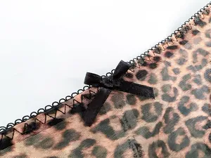 Macro view of leopard print lace lingerie featuring sheer mesh and a black satin bow.