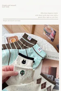 Detail showing cute cat embroidery and colorful patterns on combed cotton socks
