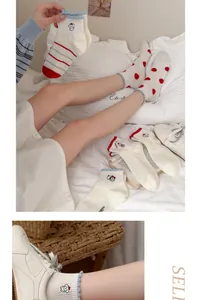 Detailed view of cozy cotton short socks with cute red cartoon dog embroidery and dots.