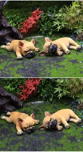 Detailed view of two cute sleeping French Bulldog car ornaments on mossy ground.