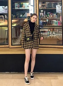 Model wearing a stylish black leather mini waist bag with a gold buckle decoration