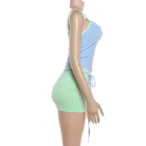 Vue latérale d'un ensemble débardeur bleu sexy et mini-jupe moulante vert menthe.