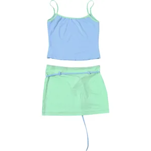 Détail d'un ensemble avec caraco bleu clair et minijupe vert menthe sur fond blanc