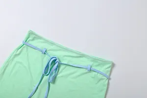 Gros plan de la taille d'une jupe vert menthe avec une ceinture à cordon bleu réglable.