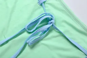 Gros plan du détail de la bride réglable bleu clair sur un tissu de robe vert menthe