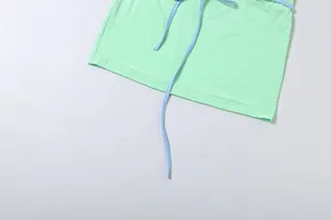 Gros plan détaillé d'une mini-jupe moulante vert menthe avec des cordons bleu clair