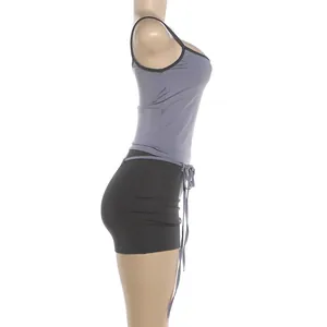 Profil latéral détaillé d'un ensemble sexy débardeur gris et mini-jupe noire.