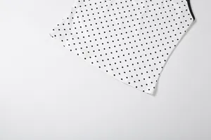 Gros plan détaillé du tissu blanc avec un motif classique à pois noirs pour ensemble féminin