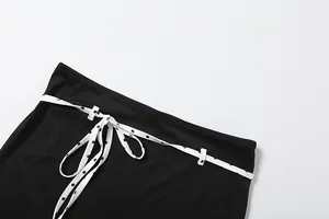 Vue rapprochée de la taille d'une jupe noire avec un détail de ceinture à pois nouée