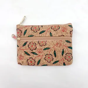 Detailopname van het bloemen- en vlinderpatroon op een natuurlijke kurken portemonnee.
