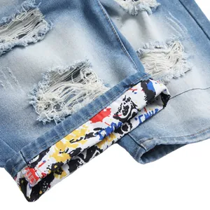 Vue détaillée du short en jean bleu déchiré pour hommes avec un ourlet à motifs colorés