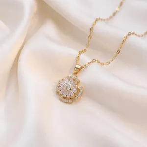 Elegant gold rotating flower pendant necklace with cubic zirconia on silk background