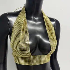 Detailed macro shot of a sexy golden rhinestone mesh halter crop top on a black mannequin