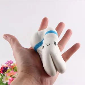 Hand squeezing a cartoon white tooth-shaped slow-rebound squishy toy for stress relief