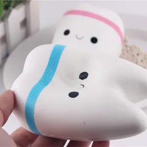 Close-up of white tooth-shaped slow rebound PU squishy toy being squeezed by hand.