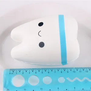 Detailed view of white tooth shaped slow rebound squishy toy with size scale ruler