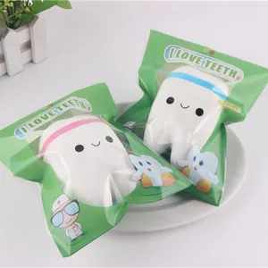 Detailed macro view of cute tooth squishy slow rebound toys in green retail bags.