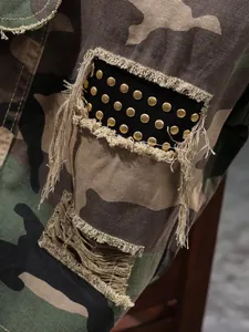 Close-up of tactical camouflage shorts showing distressed fringe and gold metal studs